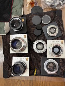 Vintage collection of six large format camera lenses. The lot includes a Schneider-Kreuznach Super-Angulon 90mm f/8 lens, a Schneider-Kreuznach Symmar