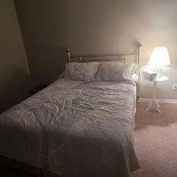 Queen Size bed with I'm mattress, box brings in metal  frame On Rollers and Brass headboard.