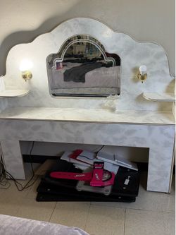 Vintage white headboard with mirror and built-in lamps.