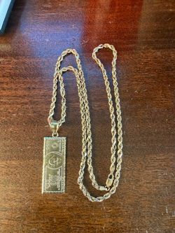 10K gold-cut by chain, approximately 28 inches, with 10K $100-bill pendant — 10.3 grams total