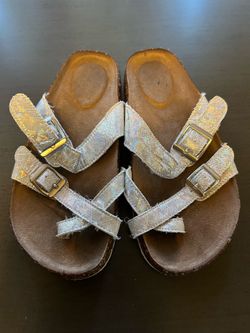 sandalias Wonder Nation de color plateado iridiscente con hebillas ajustables.