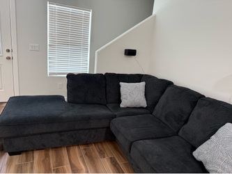 Dark charcoal gray L-shaped sectional sofa with a left-facing chaise.