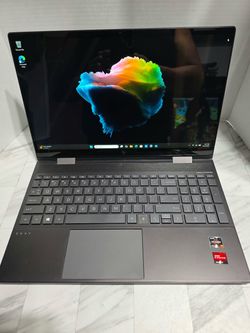 HP Envy X360 convertible touchpad laptop in dark gray with a backlit keyboard, Bang & Olufsen audio, AMD Ryzen 7 processor, and AMD Radeon graphics.