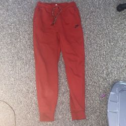 Red Nike tech pants