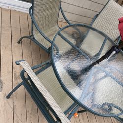 outdoor patio green round glass table 4 chairs red umbrella and base set furniture used. Crack in cap to top umbrella. Table wobbly chairs need cleani