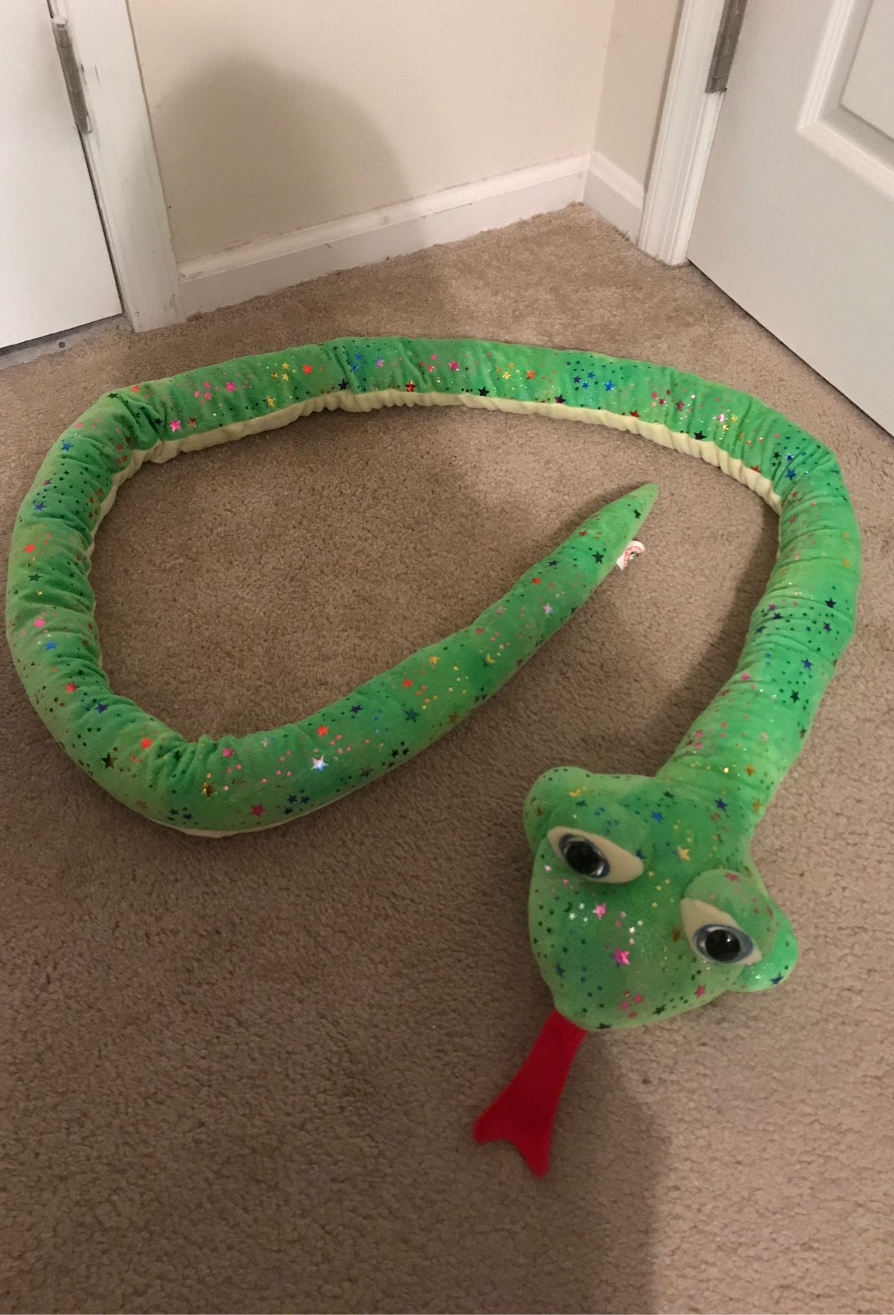 Light green stuffed animal snake with rainbow stars