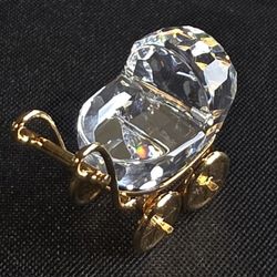 Swarovski Crystal Memories baby carriage figurine with 18K gold-plated accents.