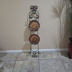 This is a decorative metal wall-mounted plate rack displaying two collectible plates featuring wildlife, specifically a lion and a leopard. 
The rack 