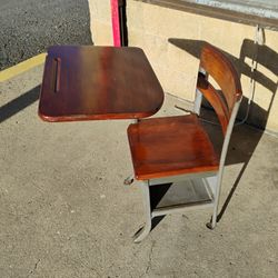 Vintage wood and metal student school desk with an attached right-arm chair and under-seat storage.