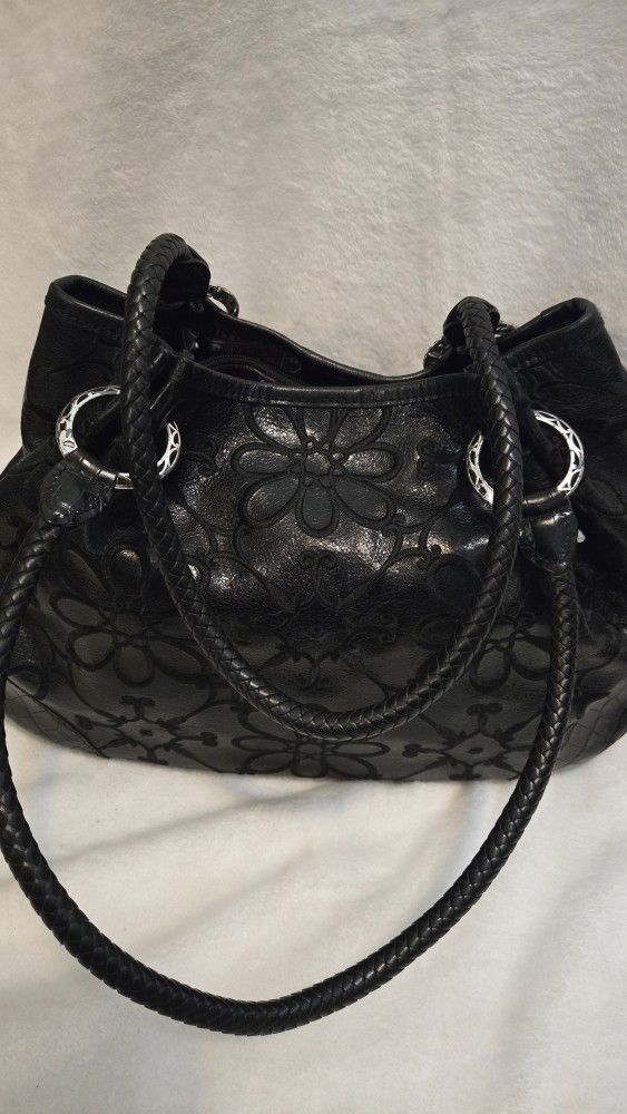 Brighton Valencia black leather shoulder bag with floral embroidery and braided straps.
