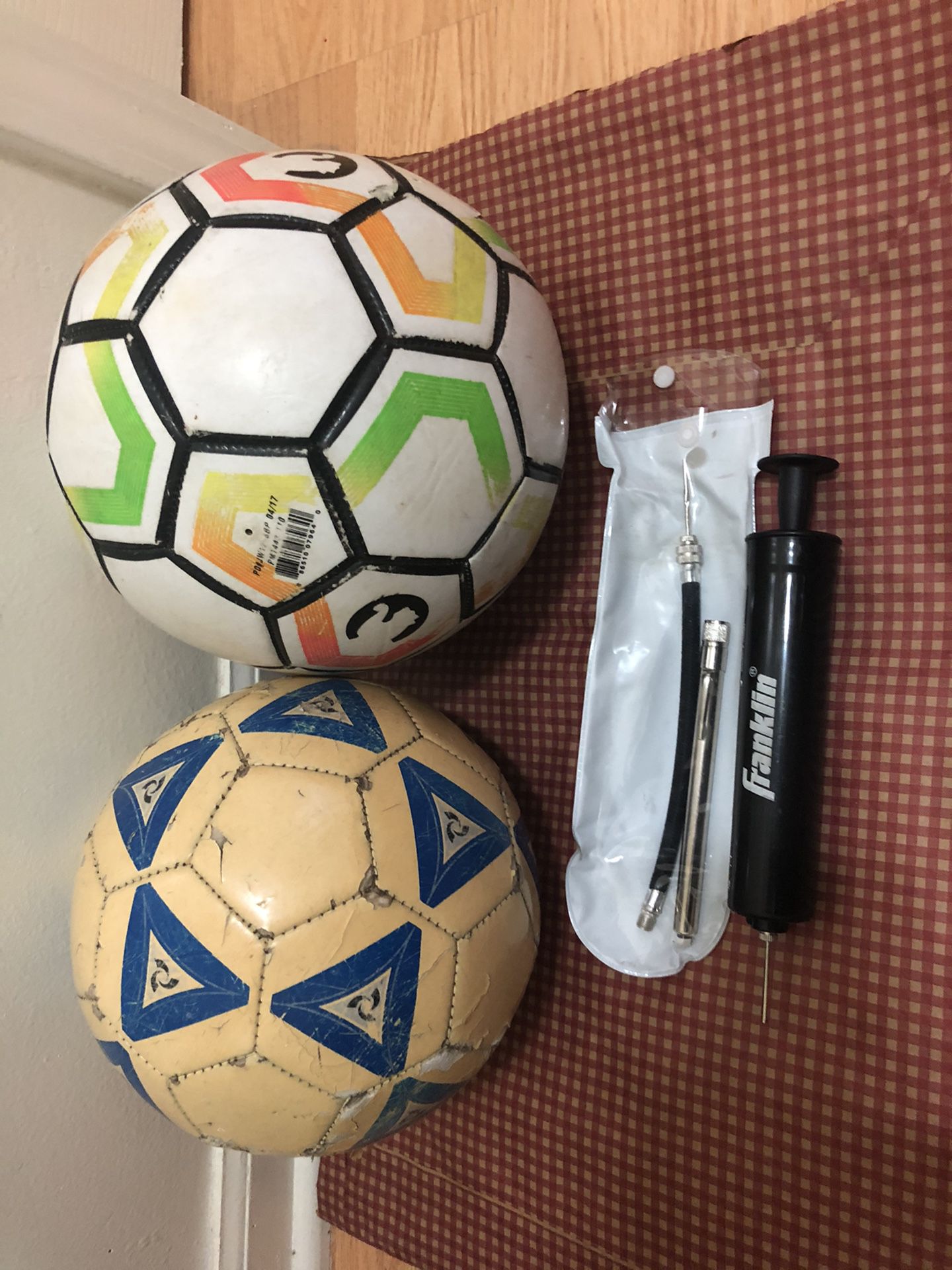 Two footballs + Franklin Sports Ball Maintenances Kit: pump , needles, & pressure gauge.