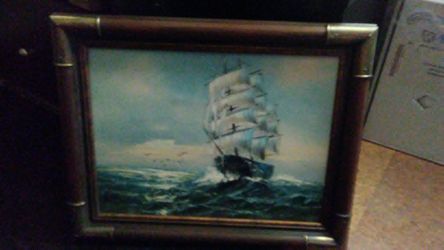 2 antique pictures of a ship and one of a sailor they are both about waste high from the ground