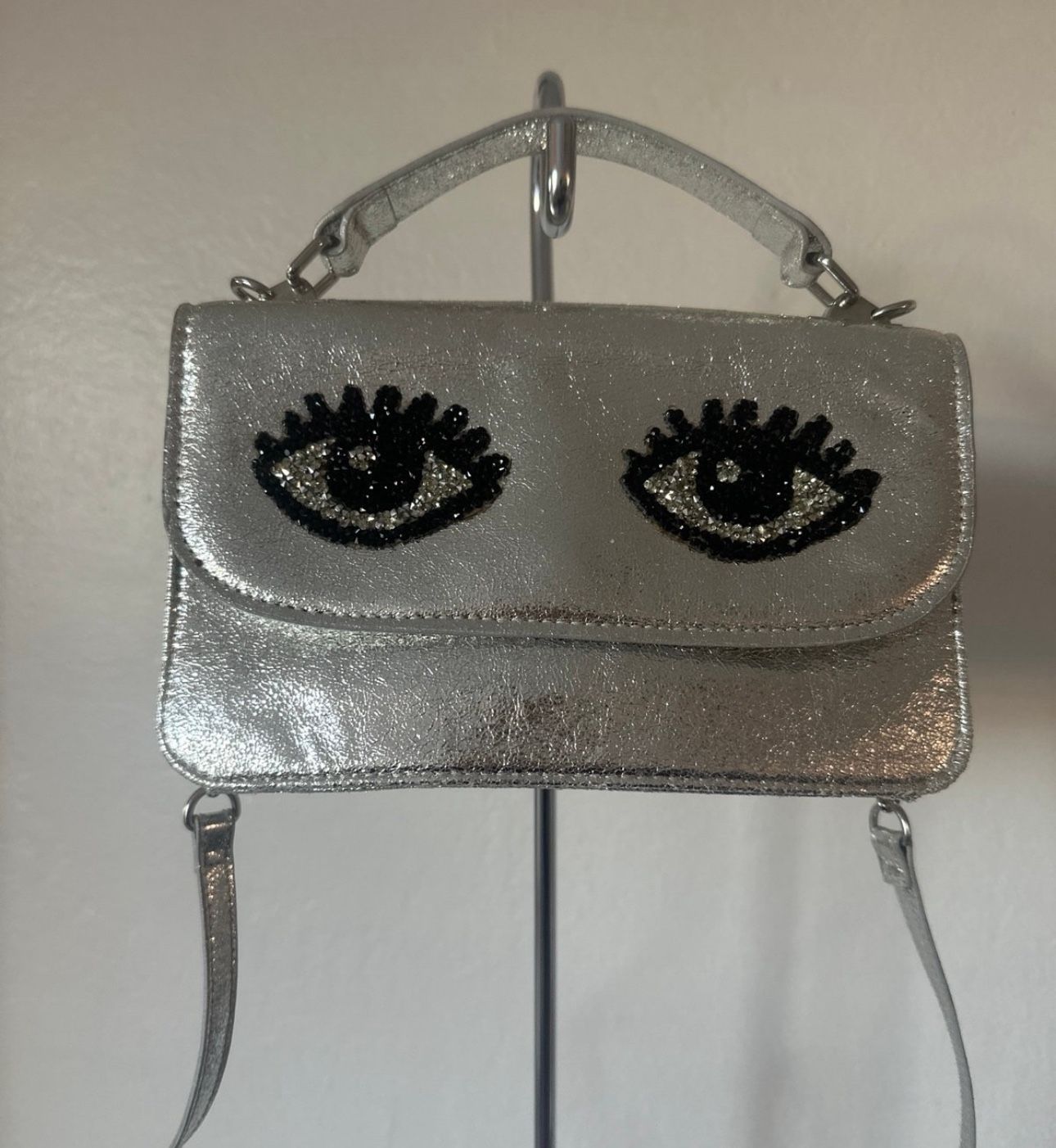 Betsy Johnson Silver Black Eye Top Handle Crossbody Purse.. pre owned very good condition.. This bag is so cute and very fashionable! This purse has c