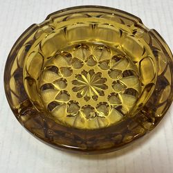 This item is a vintage mid-century modern amber glass ashtray, specifically