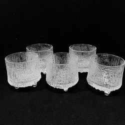 Littala Ultima Thule Liquor Glasses Set of 5 designed by Tappio Wirkkala in 1963 and 2.75” tall. Distinctive textured ice pattern and tri-footed base.