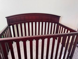 A crib and a changing table with a changing pad