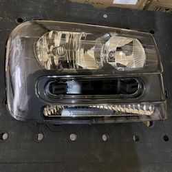 New In Box Chevy Trailblazer Headlight Assembly Black With Chrome 