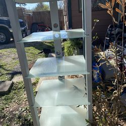 four-shelf frosted glass and metal electronics entertainment center or multimedia shelving unit.