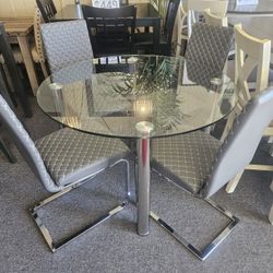 Brand new 48" round glass dining table + 4 black faux leather chairs