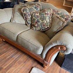 Mediterranean style cloth covered loveseat with nail head detailed embossed trim in solid wood. 