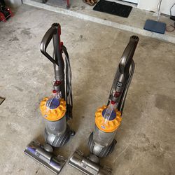 pair of Dyson vacuums 