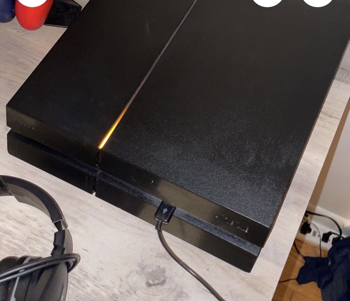 ps4 with 2 controllers, headset, and charging dock