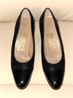 Salvatore Ferragamo black textured patent leather heels with a vintage-style toe cap. The rest of the shoe has a subtle texture. Made in Italy.