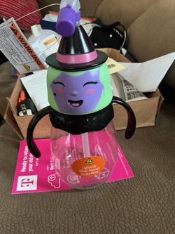 Halloween light-up witch sippy cup featuring a purple witch face topper, dual side handles, and a flexible straw, designed to light up when tapped on 