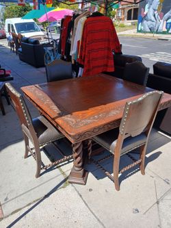 Spanish Revival style dining set features intricate hand-carved glass top
