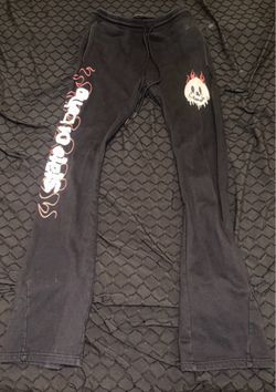 Black stacked sweatpants with red and white lettering and yellow graphic photo