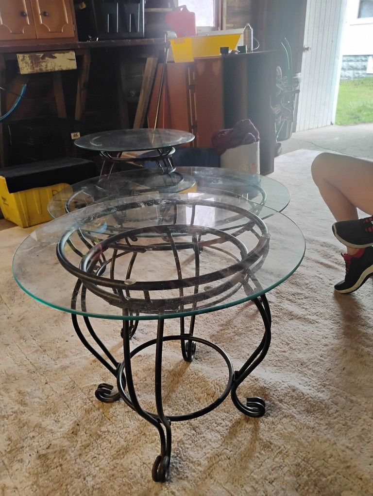 A Glass Top Coffee Table With Wrought Iron Stand And Two Glass Top End Tables With Wrought Iron