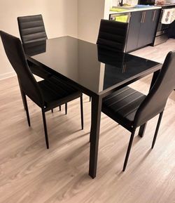 Glass dining table with four chairs. Like new.