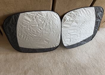 Pair of reflective car sun shades.