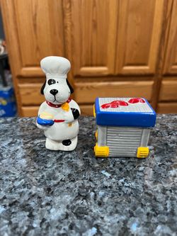 Vintage Russ Dog Chef And Hot Dog Grill Shaped Pair of Salt and Pepper Shakers .  Size approximately 3 1/2 inches tall.  Brand new never used with tag