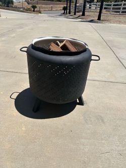 Fire Pit made from washing machine tub with legs, handles and scrap firewood