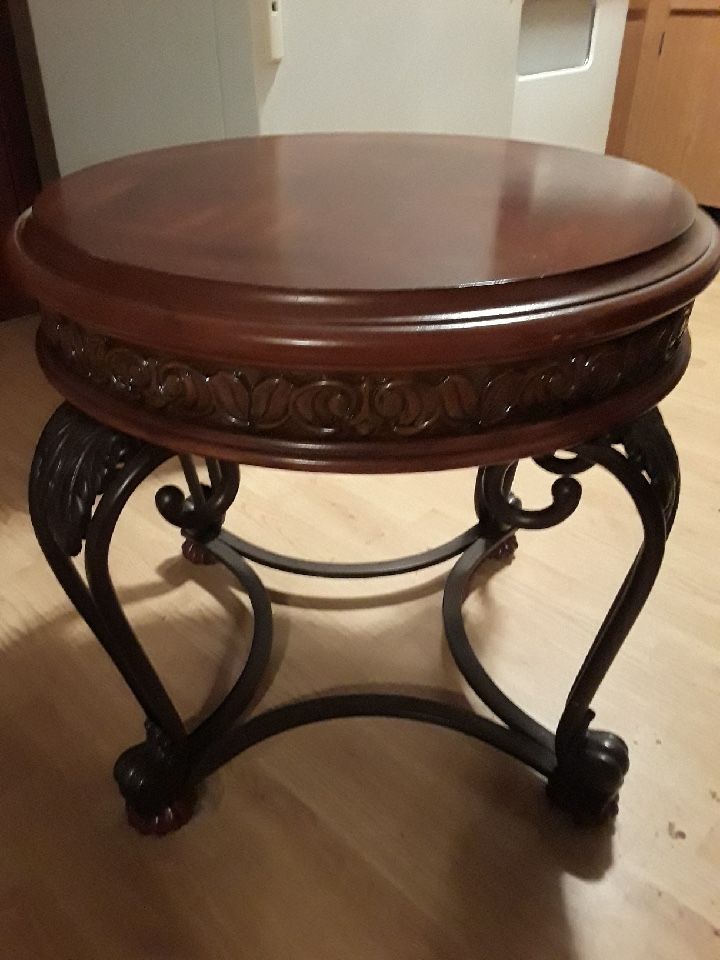 Round Wood/Metal Table Used as end or coffee table. Carved wood accent trim.