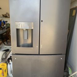 Black GE refrigerator with built-in water dispenser. Freezer works fine. Refrigerator needs air/ gas to cool at 100%.