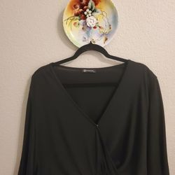 Black wrap-style crop top with a deep V-neckline and wide, flowing sleeves
