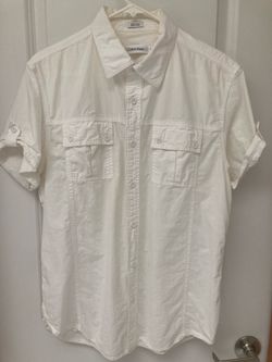 Calvin Klein white short-sleeve button-down shirt with a point collar, dual chest pockets, and rolled sleeves with button tabs. Men size medium.