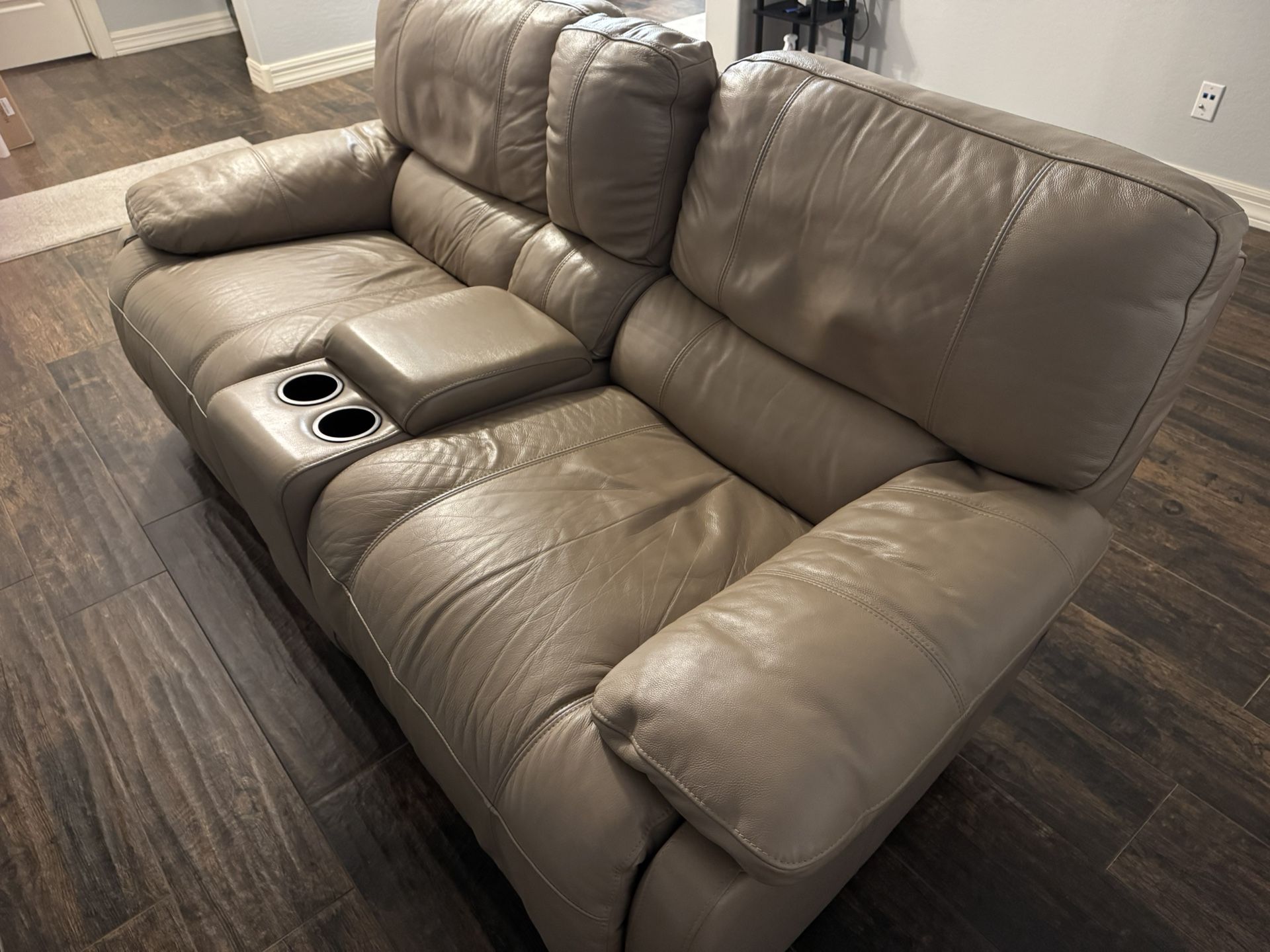 Two-seat leather reclining loveseat with a built-in console