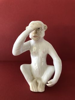 White Ceramic Monkey its hand covering its eyes like the "see no evil" .