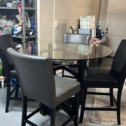 It is a tall, round table. It comes with four chairs;tear. .