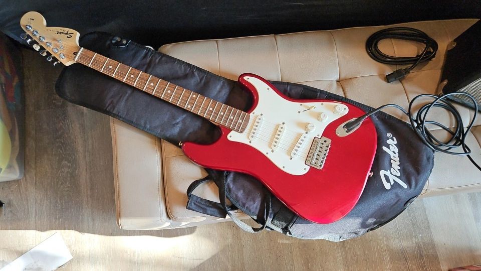 Red Fender Squier Electric Guitar With Qmp, Cables, Case, Strap, Capo And Some Replacement Strings