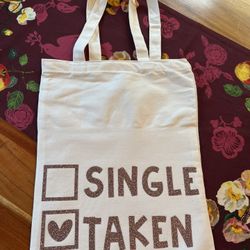 Stylish white tote bag featuring a playful 'Single Taken' print. Perfect for casual outings and daily use. Valentine’s love sparkles and glitter. Hand