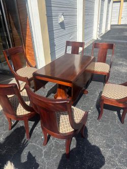 Solid  oak wood dining table with six chairs & pedestal base and drop leaf