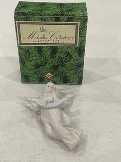 Porcelain angel Christmas tree ornament with a banner reading Joy. by Russ Berrie. The Marbella Collection