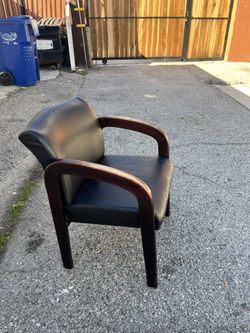 Comfortable vintage office guest chair with a sturdy solid-wood frame and classic curved arms. The vinyl seat and back appear clean but do show some c