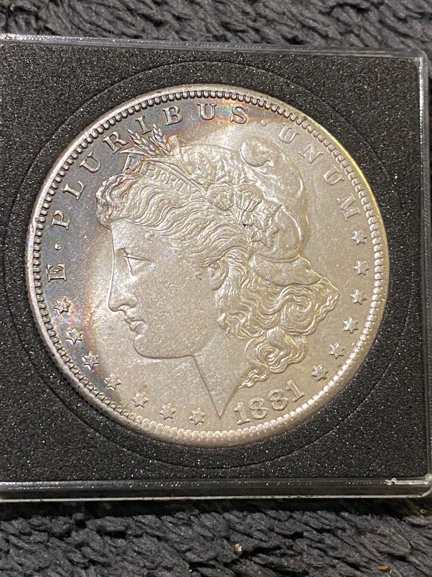1881 – S silver Morgan Dollar with full spectrum rainbow toning crescent on front