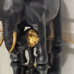 Two sets of black and gold elephants