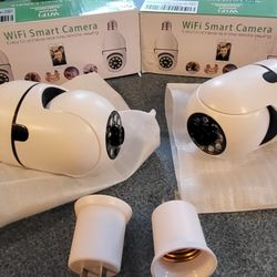 2 WiFi Smart Cameras Light Bulb Or Plug In Use, Rotating, Phone Controlled. SD Card Light And More Functions 